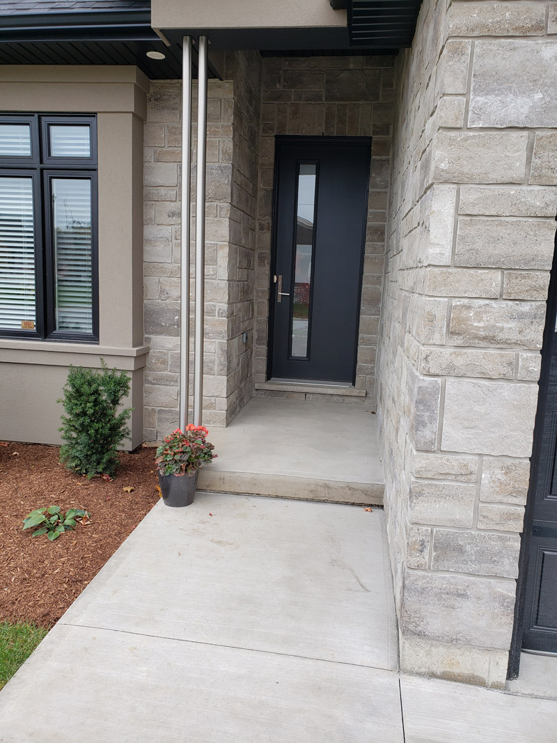 Front entrance of a house with two custom aluminum poles