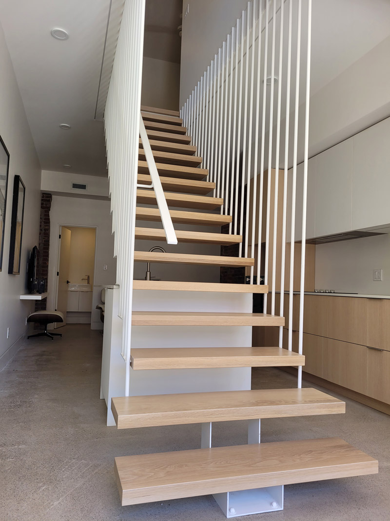 Beautiful custom floating stairs with metal railings holding it up